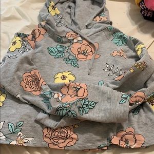 a slightly cropped grey hoodie with floral design
